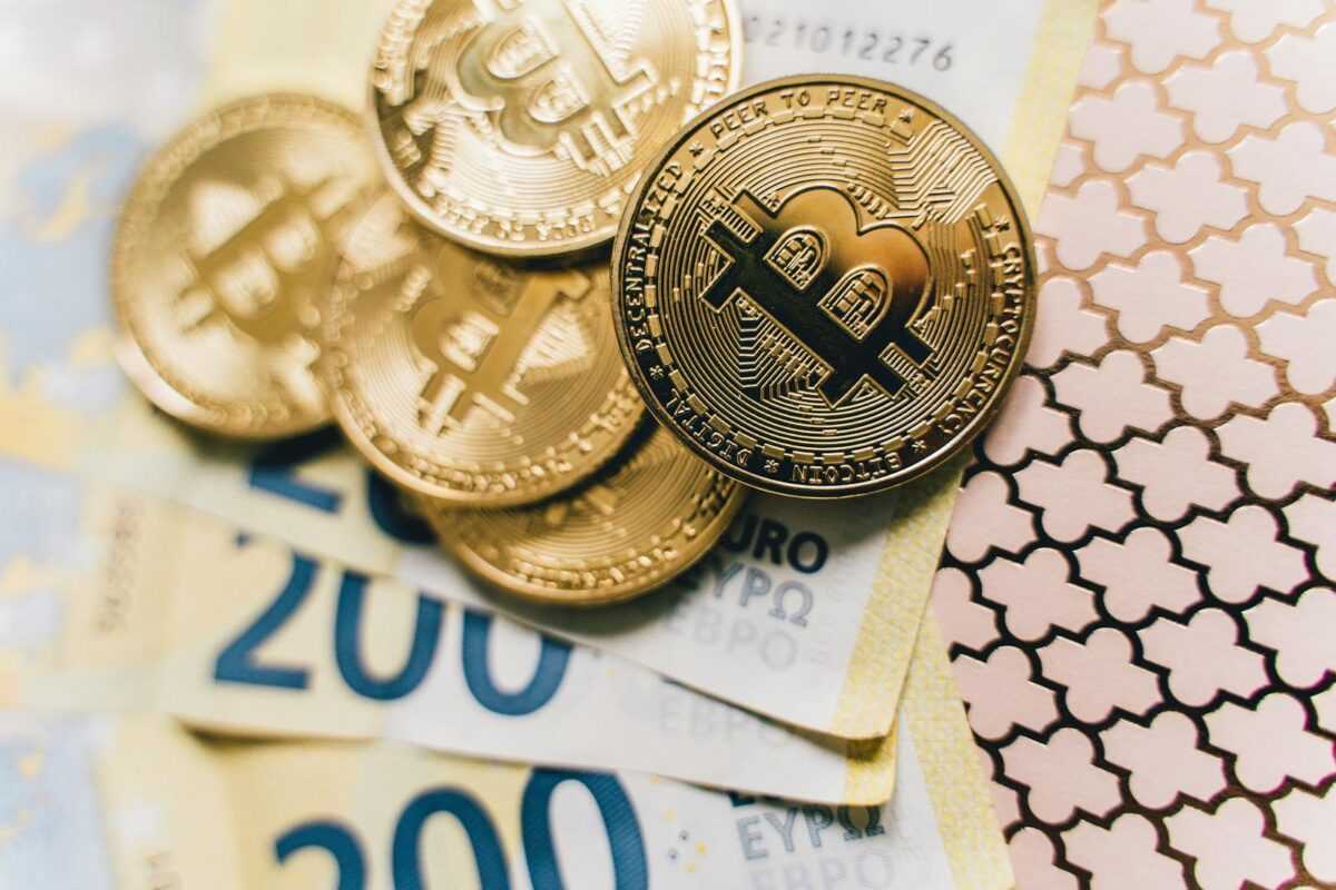 Close-up of Bitcoin coins on Euro banknotes, symbolizing cryptocurrency exchange.
