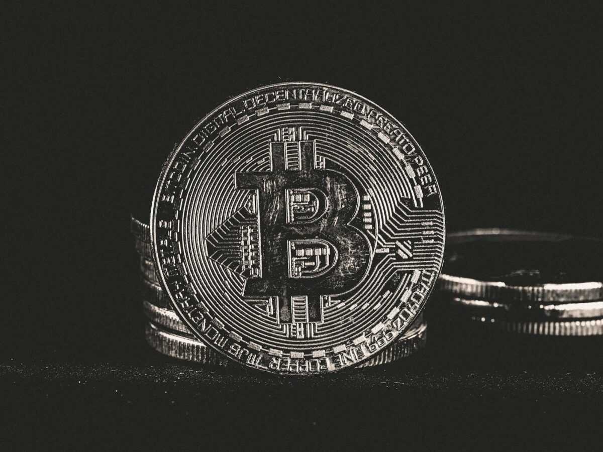 Detailed image of a silver Bitcoin coin on a dark background, highlighting cryptocurrency themes.